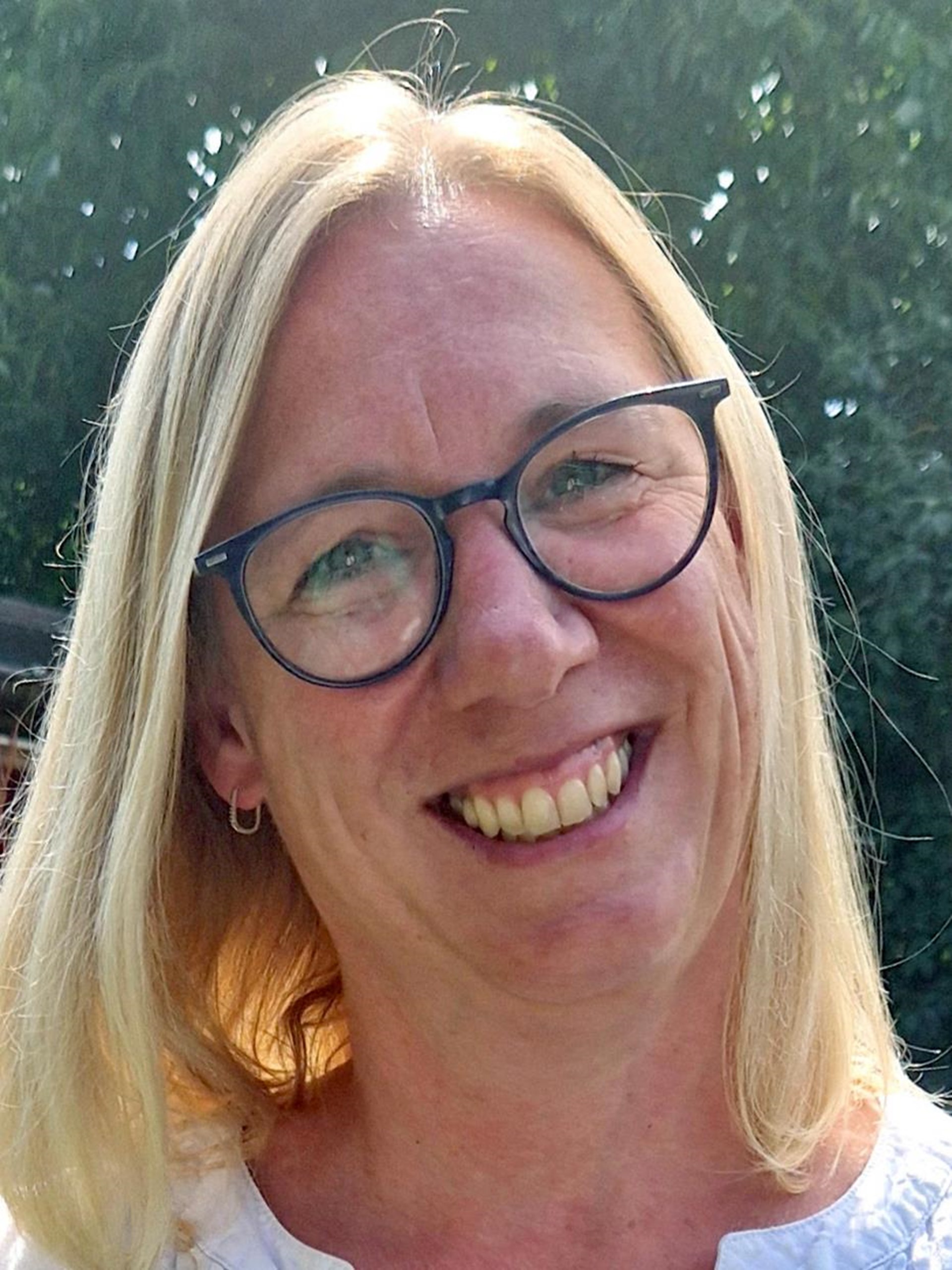 Blonde Frau mit Brille im Porträt. 